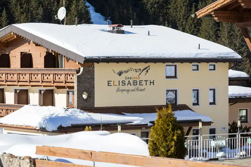 Fassade mit Schriftzug Das B&B Elisabeth – Ursprung und Heimat im Winter
