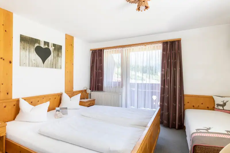 Doppelzimmer mit Zirbenholz, Herz-Bild, zusätzlichem Einzelbett und Balkontür
